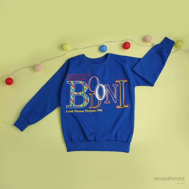 Blue kids graphic sweatshirt styled with festive fairy lights