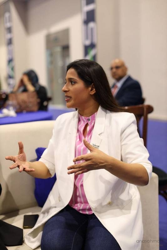 Businesswoman gesturing while speaking at a corporate panel discussion