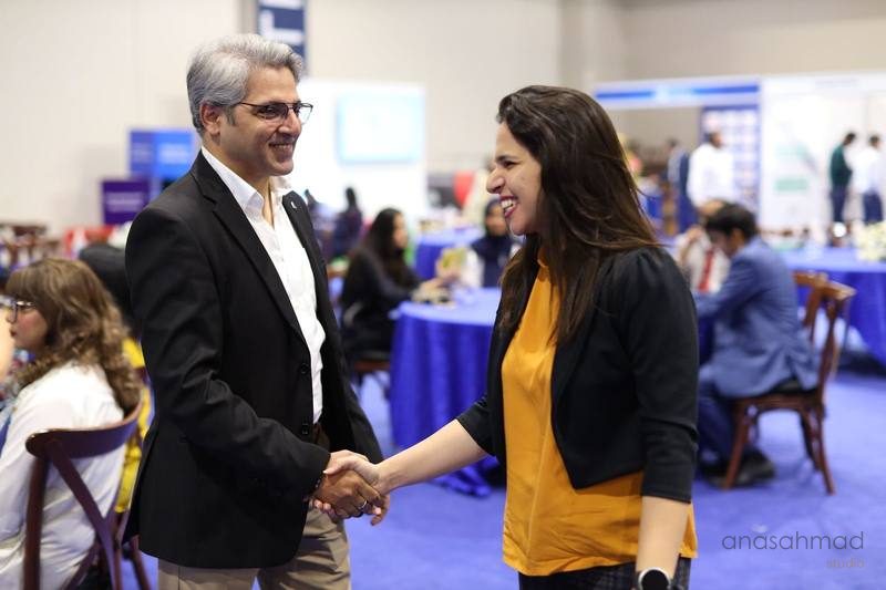 Two business professionals shaking hands at a corporate networking event