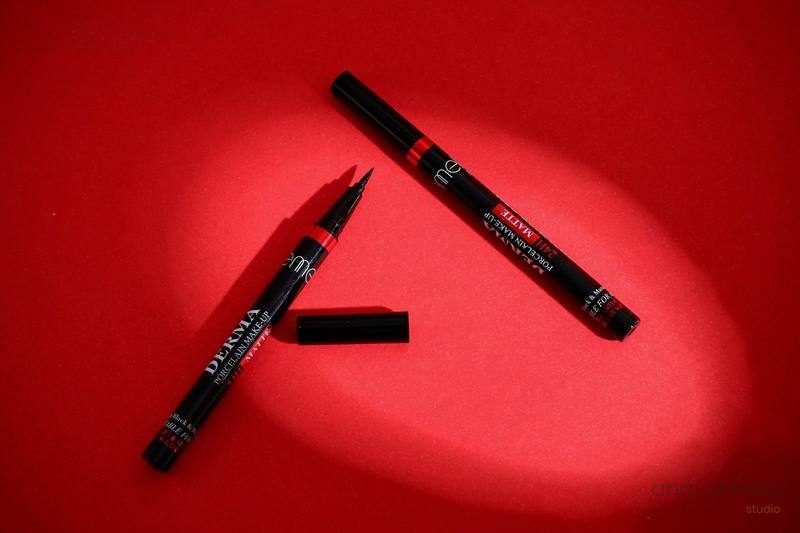 Two black eyeliner pens on red background
