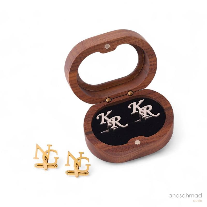 Wooden cufflink box with engraved KR monogram cufflinks and gold NG cufflinks beside it