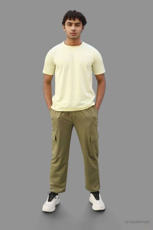 Male model in pastel yellow t-shirt and olive cargo pants, studio shot