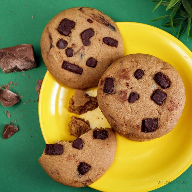 Chocolate chip cookies on a yellow plate with chocolate chunks