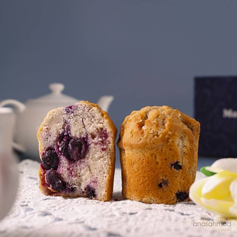 Blueberry muffins sliced in half showing berry-studded crumb