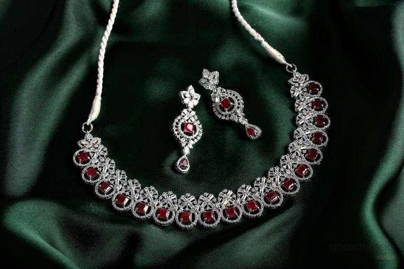 Ruby and diamond necklace and earring set on emerald green silk