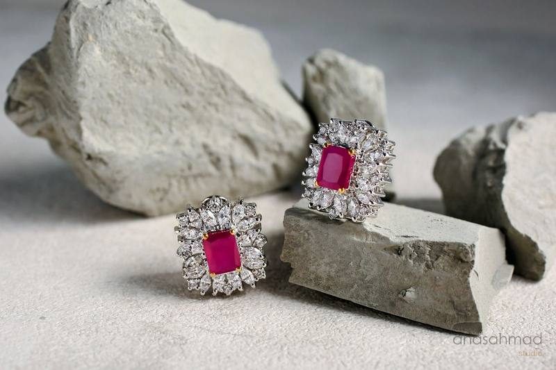 Ruby and diamond cluster earrings styled on natural stone