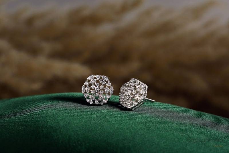 Pave diamond stud earrings on green velvet fabric