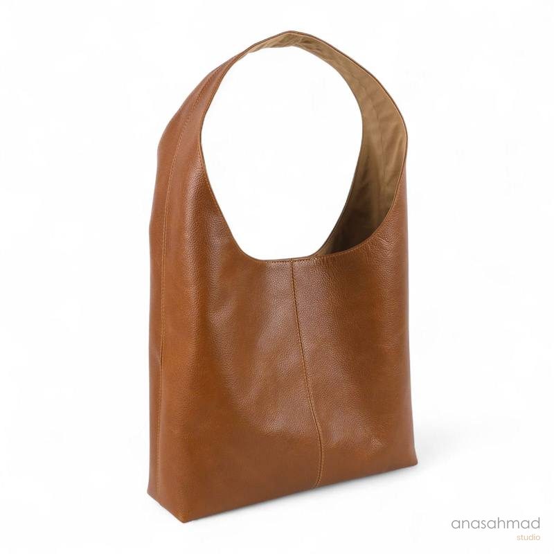 Cognac leather hobo shoulder bag, side angle on white background