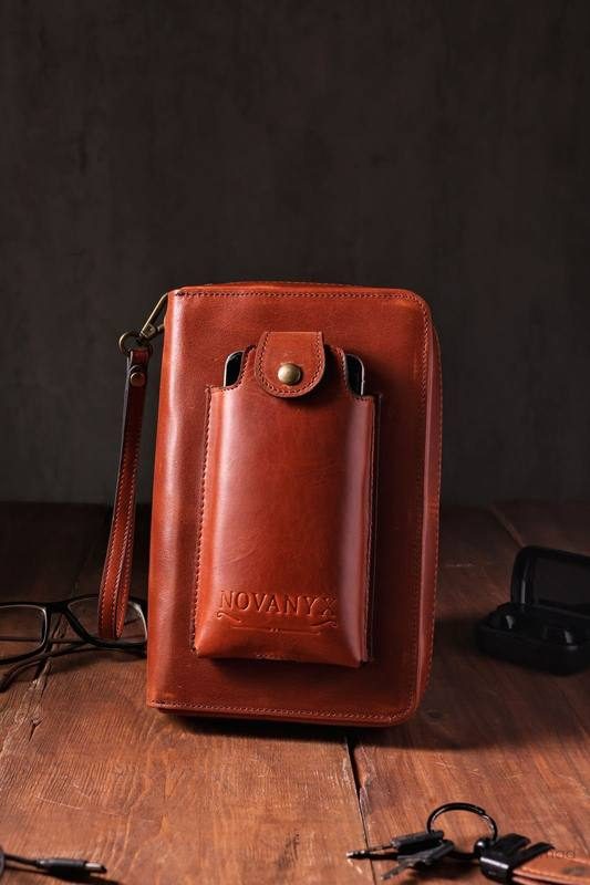 Novanyx tan leather travel organizer, upright styling with glasses and keys on dark wood