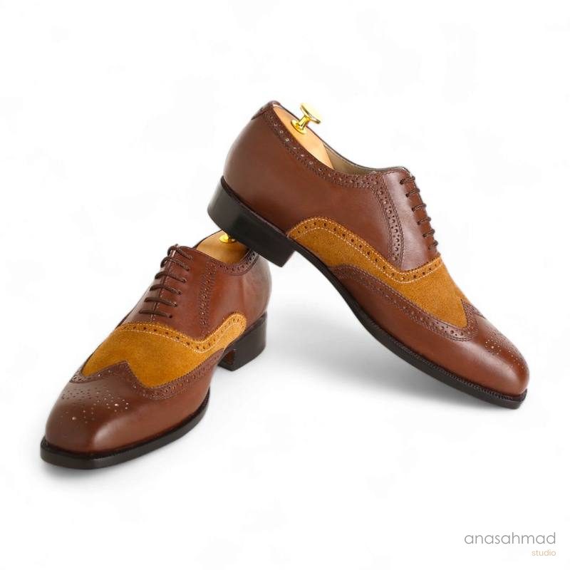 Two-tone brown and tan suede brogue wingtip dress shoes, pair on white background
