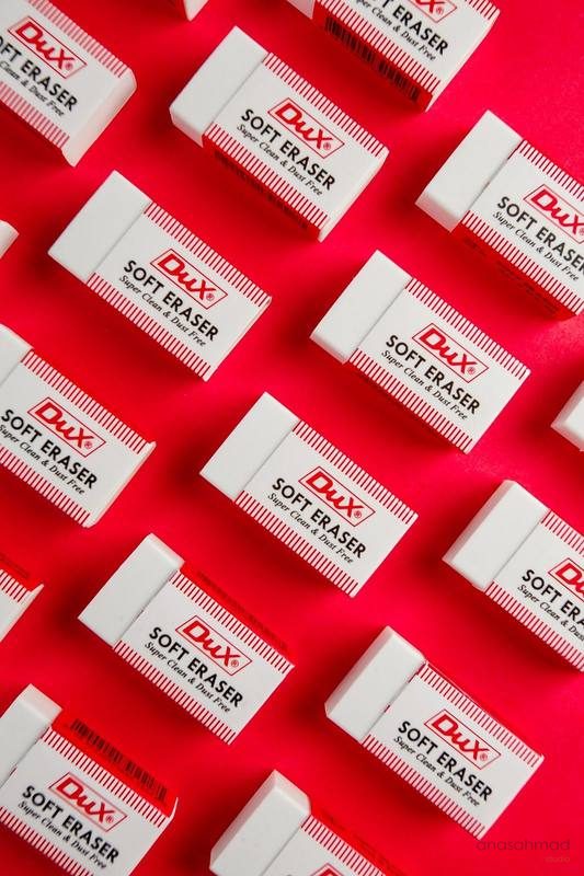 Dux Soft Eraser boxes arranged in repeating pattern on red background