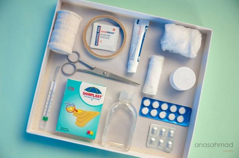 Comprehensive first aid kit flatlay with bandages, scissors, thermometer and medicine