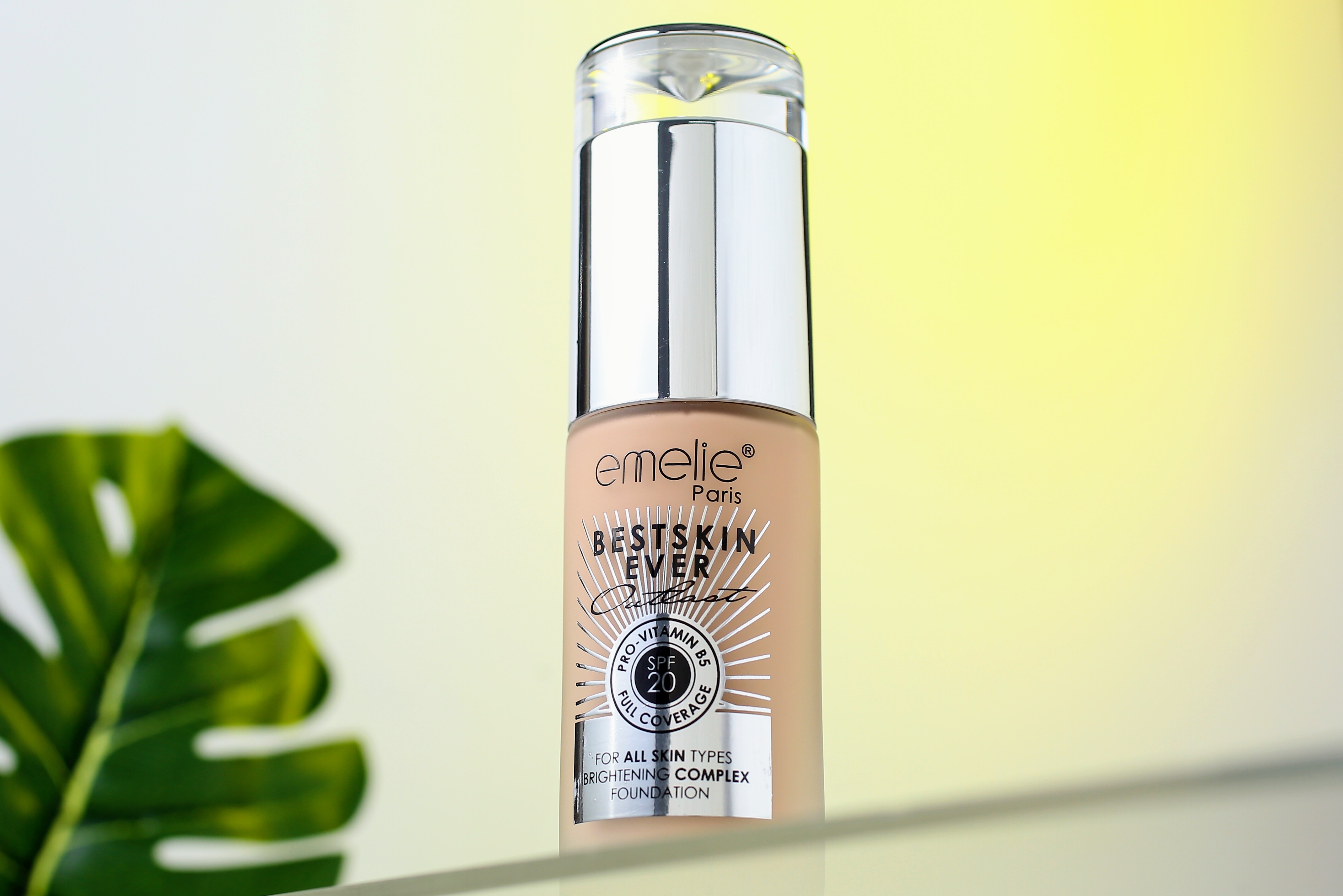 Liquid foundation bottle with transparent cap on light background